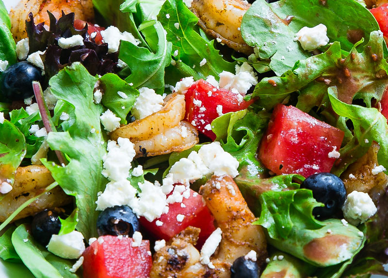 Green salad with watermelon, blueberries, shrimp and goat cheese